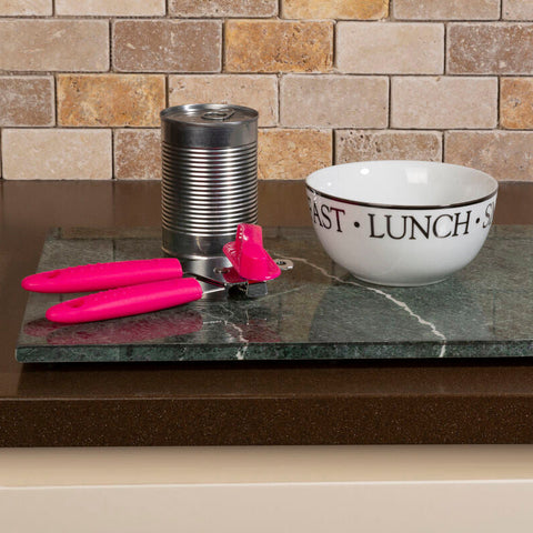 Hot pink can opener with chromed steel base resting on dark green marble tray perfect for hot range kitchens