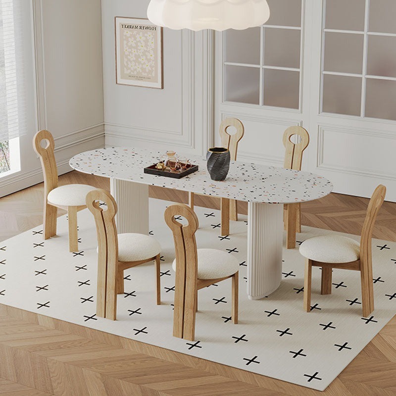 White terrazzo dining table humphry with black speckles oval top and light wood legs perfect for dining spaces