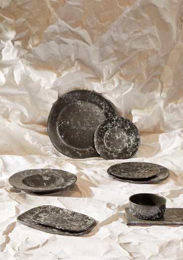 Set of dark gray speckled ceramic dinnerware including a black faux marble bowl with rustic textured finish