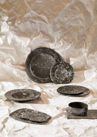 Set of dark gray speckled ceramic dinnerware including a black faux marble bowl with rustic textured finish