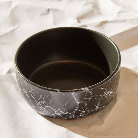 A sleek black faux marble bowl with a striking white ceramic marble pattern on its exterior perfect for hygge decor