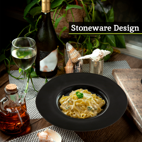Black stoneware pasta bowl with wide rim holding creamy pasta garnished with parsley hygge black pasta bowl