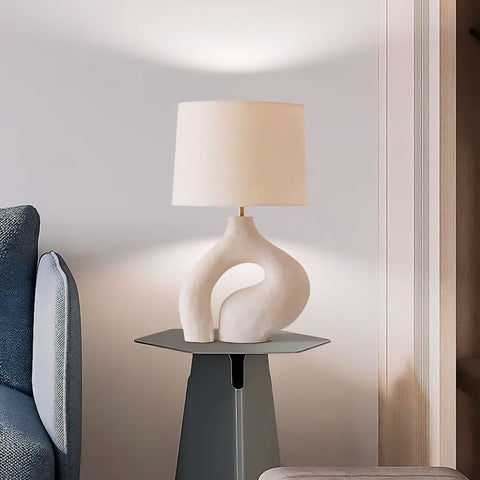 Cream-colored ceramic hyung light table lamp with sleek abstract sculptural base and soft beige fabric shade