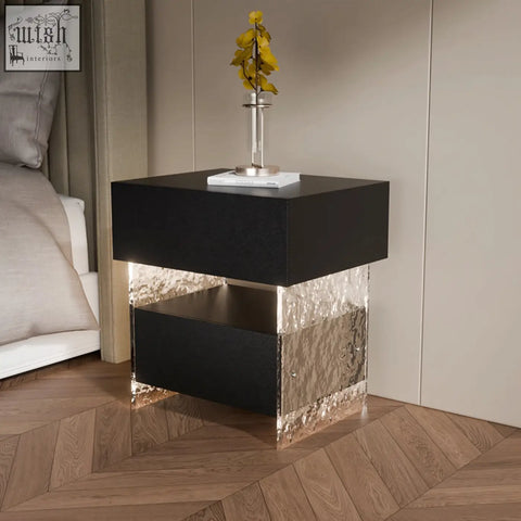 Black and silver ibarra bedside table with glossy black top, textured metallic sides, and open shelf for storage and light strip