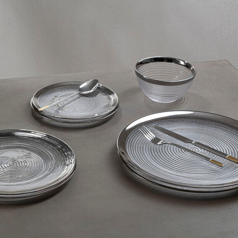 Set of silver-toned ceramic plates with embossed glass bowls featuring concentric ridges and silver rims with cutlery