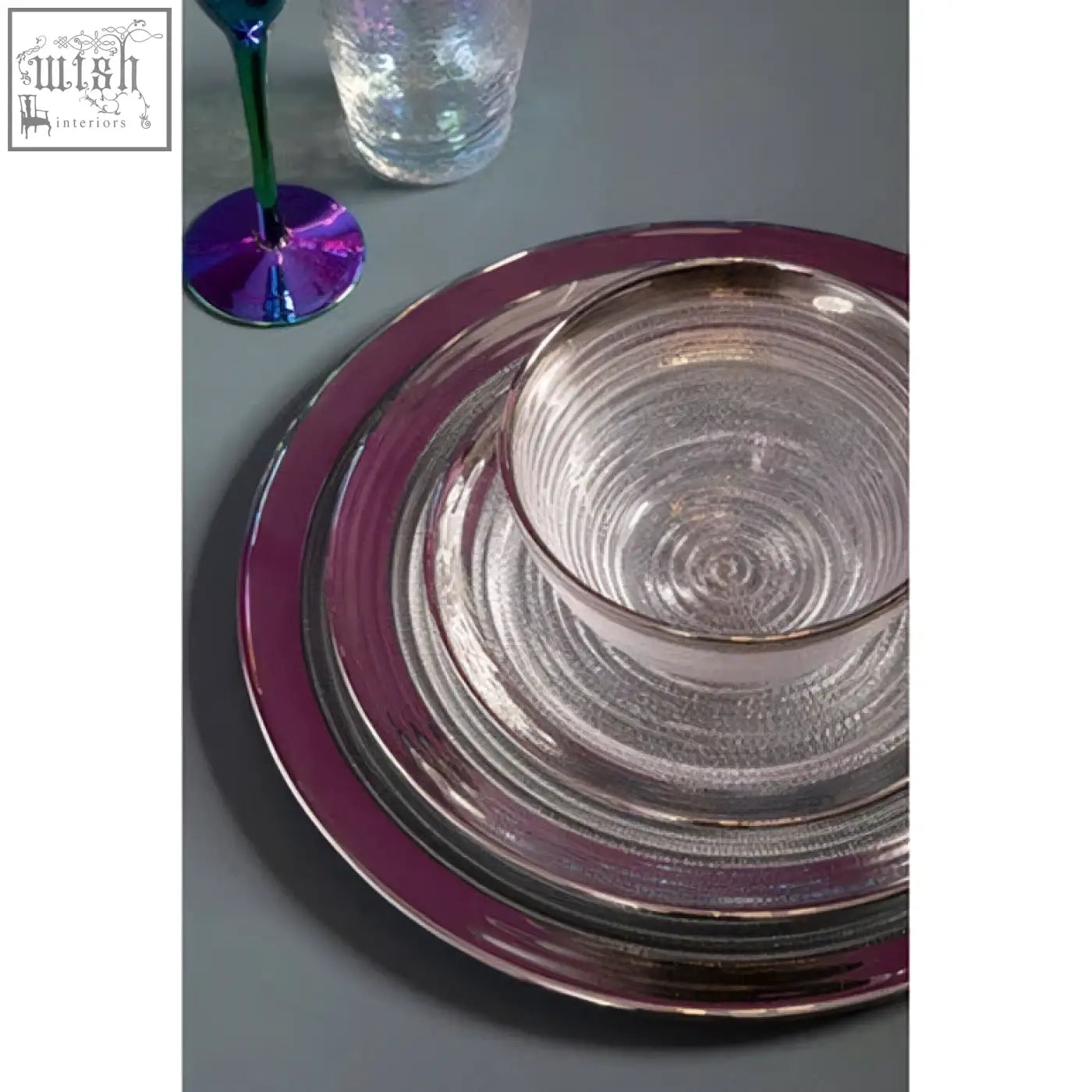 Set of clear glass coupe charger plates with shimmering purple rim and concentric circular patterns