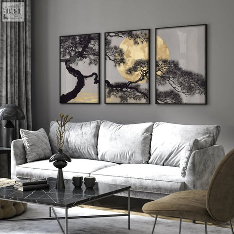 Three framed living room wall art pieces featuring black pine branches and golden moon above gray velvet sofa