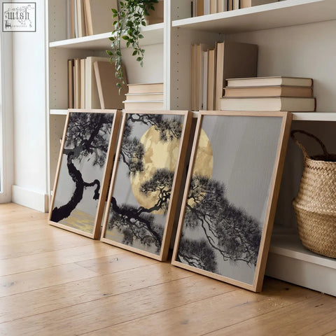 Three framed living room wall art pieces with black pine trees and gold circles on grey in light wood frames
