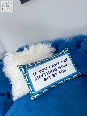 Blue and white needlepoint cushion with green velvet geometric border featuring if you cant say anything nice text