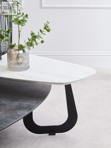 Modern large asymmetrical ceramic coffee table with white marble top and sleek black metal legs for stylish living rooms