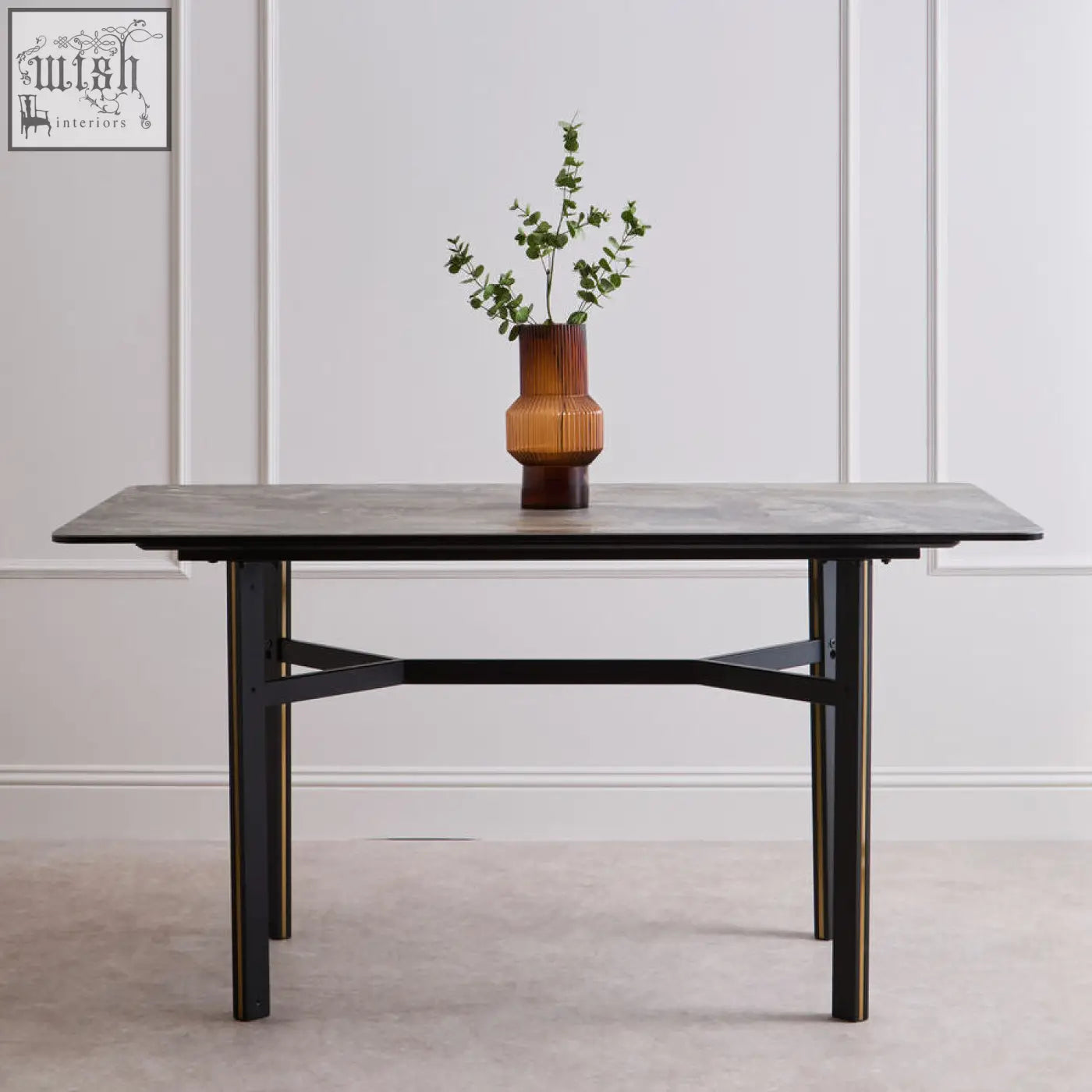 A sleek dark gray ceramic marble effect rectangular dining table with black metal legs and modern x-shaped stretcher design