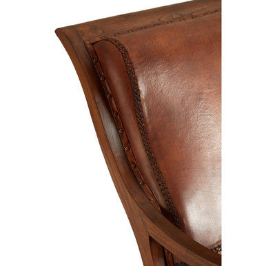 Inca brown leather armrest on brown chair with stitched detailing and brass nailhead trim in lounge chair with footstool