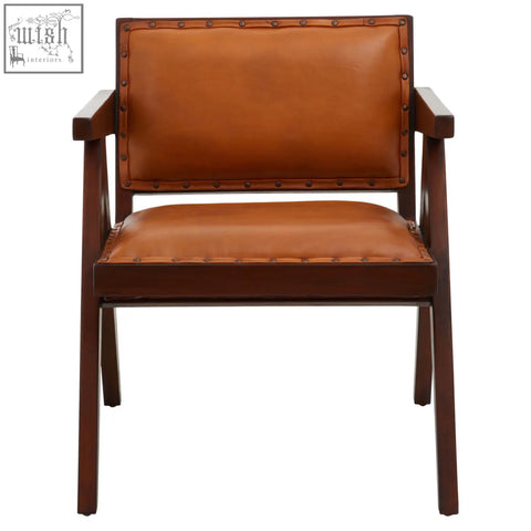 Brown leather armchair with tan leather upholstery teak frame dining chair with decorative brass studs along edges