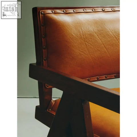 Tan leather dining chair with teak frame and brass nailhead trim perfect for frame dining setups