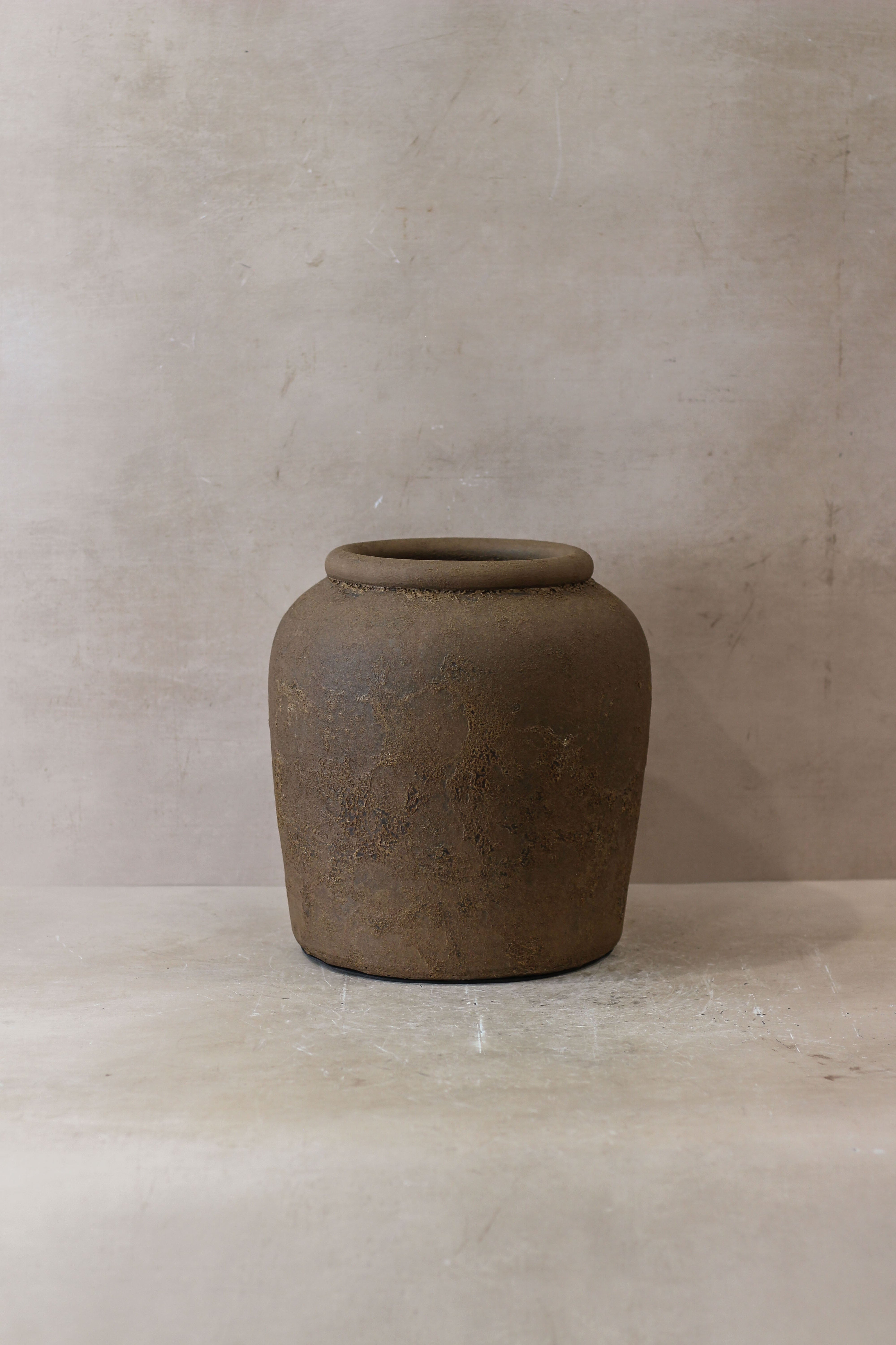 Earthenware ceramic jar indonesia pot no 17 with rounded body flared rim and textured muted brown surface