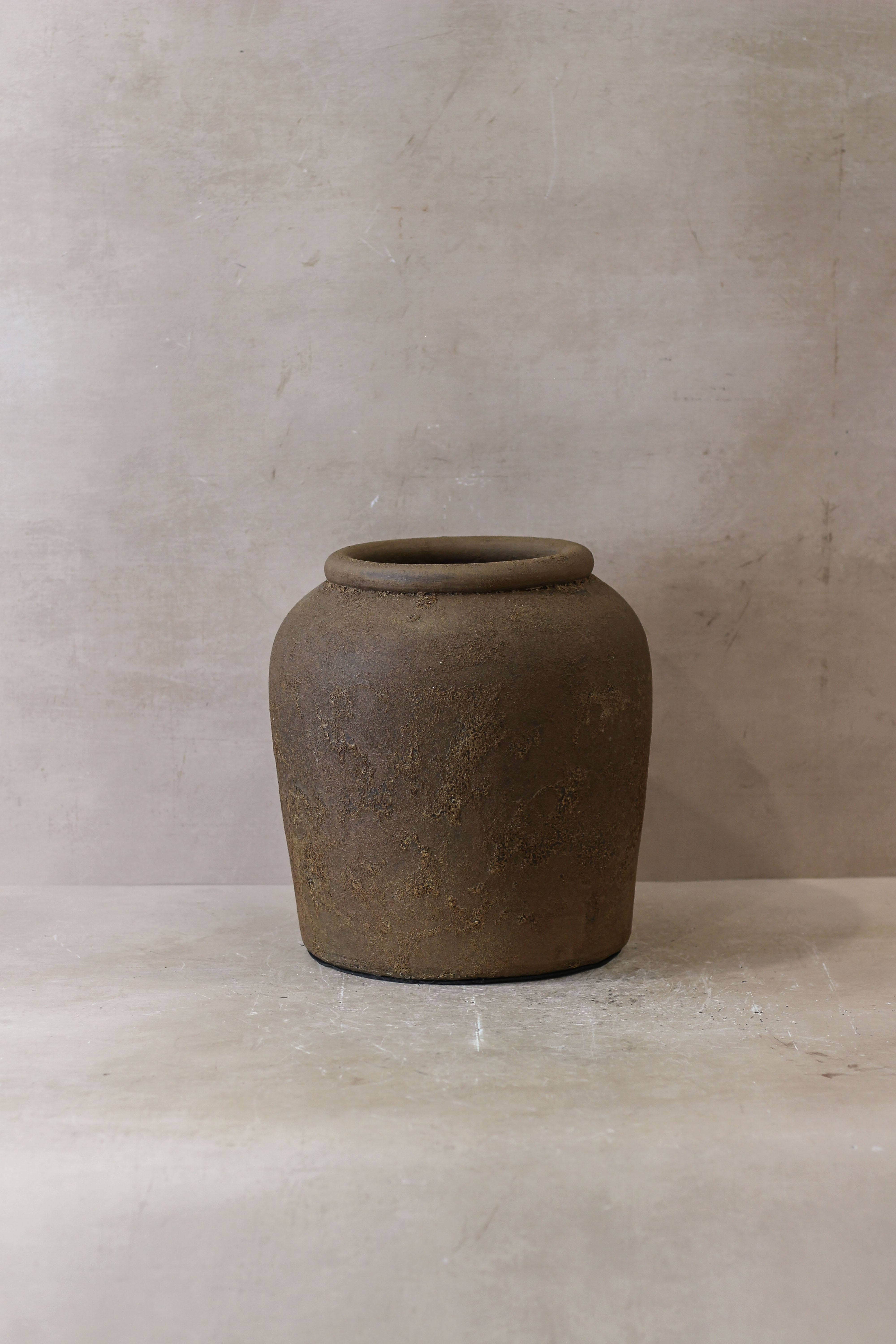 Earthenware indonesia pot no 17 with rounded body flared rim and textured surface in muted brown tones