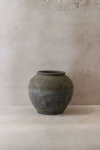 A weathered round ceramic jar with matte gray finish and subtle blue gray patina called indonesia pot no 28