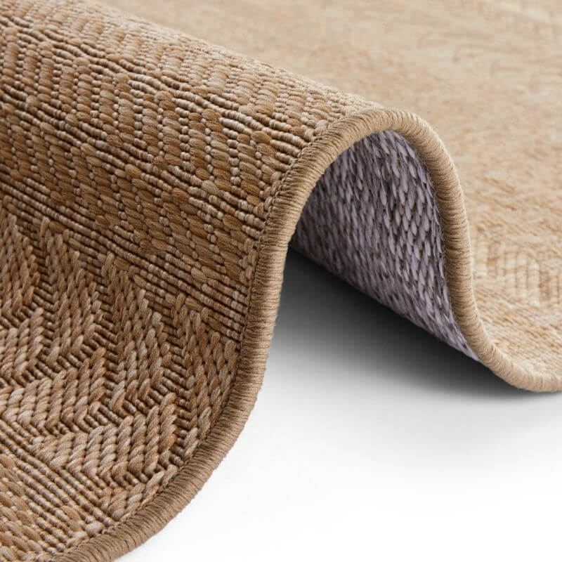 Beige indoor outdoor granado rug with chevron sisal-look woven herringbone pattern and matching braided edge