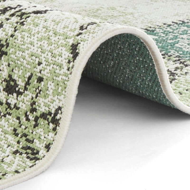 Indoor outdoor symi rug with textured green and white pattern and soft plush surface perfect for all spaces