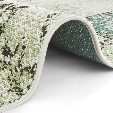 Indoor outdoor symi rug with textured green and white pattern and soft plush surface perfect for all spaces