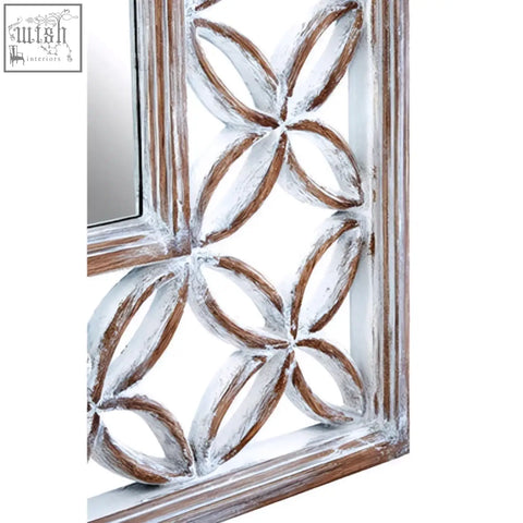 A rustic antique white wall mirror with a white lattice wooden frame featuring an interlocking oval pattern