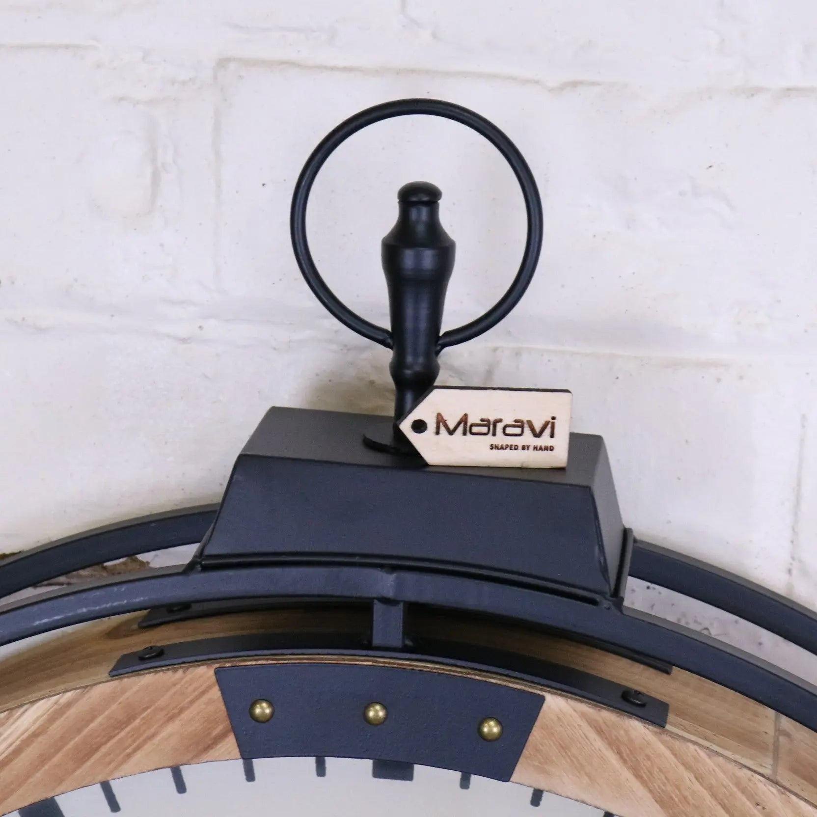 Black metal industrial large cog clock with wooden frame brass accents and maravi brand tag in white and gold style