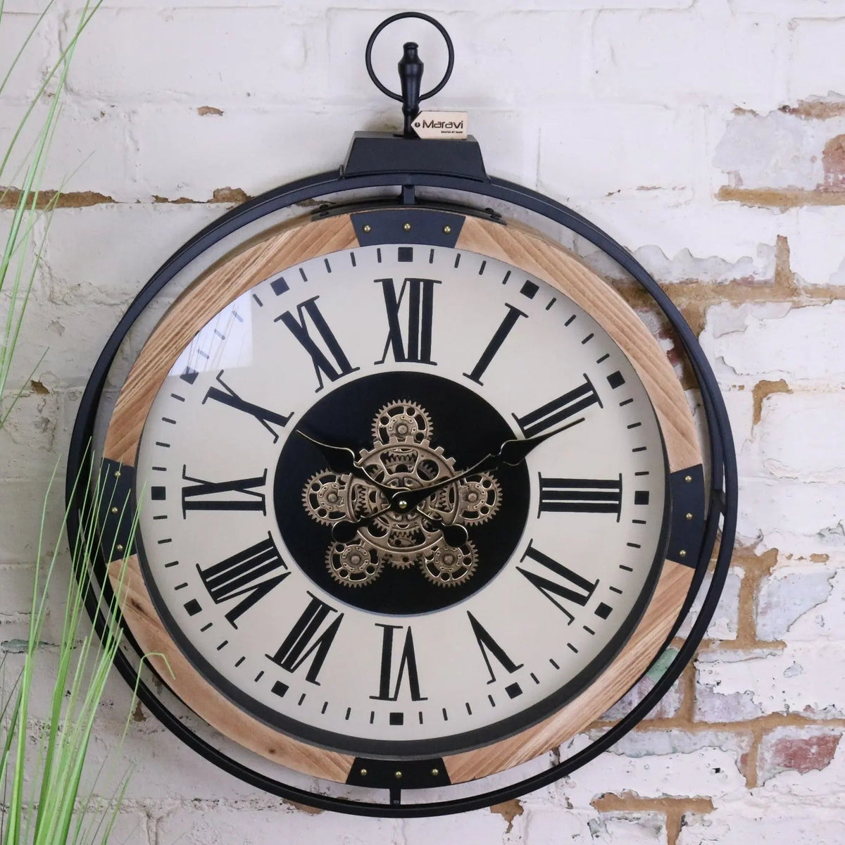 Industrial large cog clock with black metal frame light wood accents cream face roman numerals and brass gears