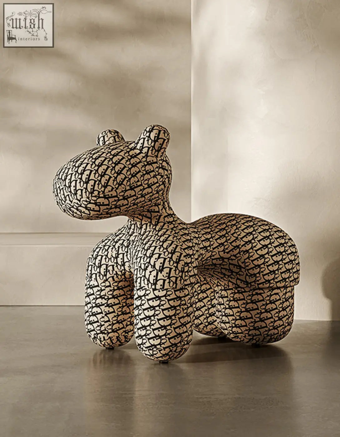 A cream-colored plush hippo kids armchair with black monogram upholstery perfect for a fun coffee table set area