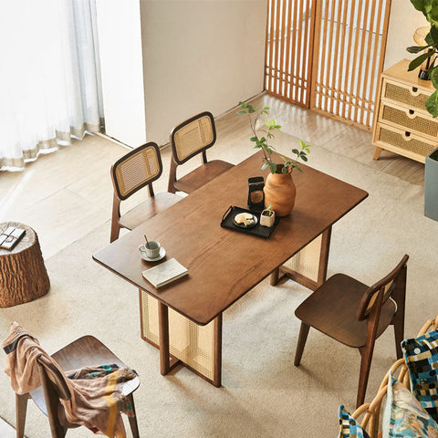 Warm-toned isla dining table with rattan cane-lattice legs and matching woven backrest chairs in solid wood
