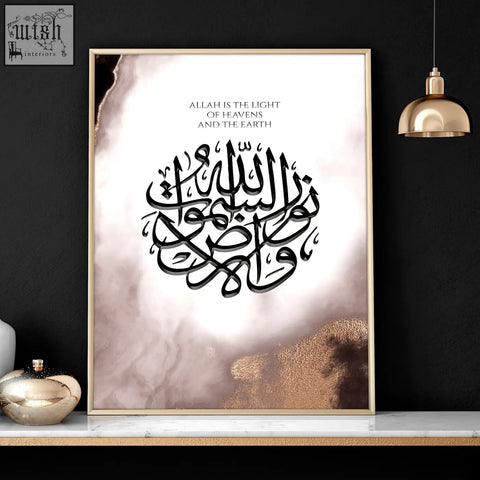 A framed islamic calligraphy art print with black script on white and gold marbled background in a gold frame wall art print