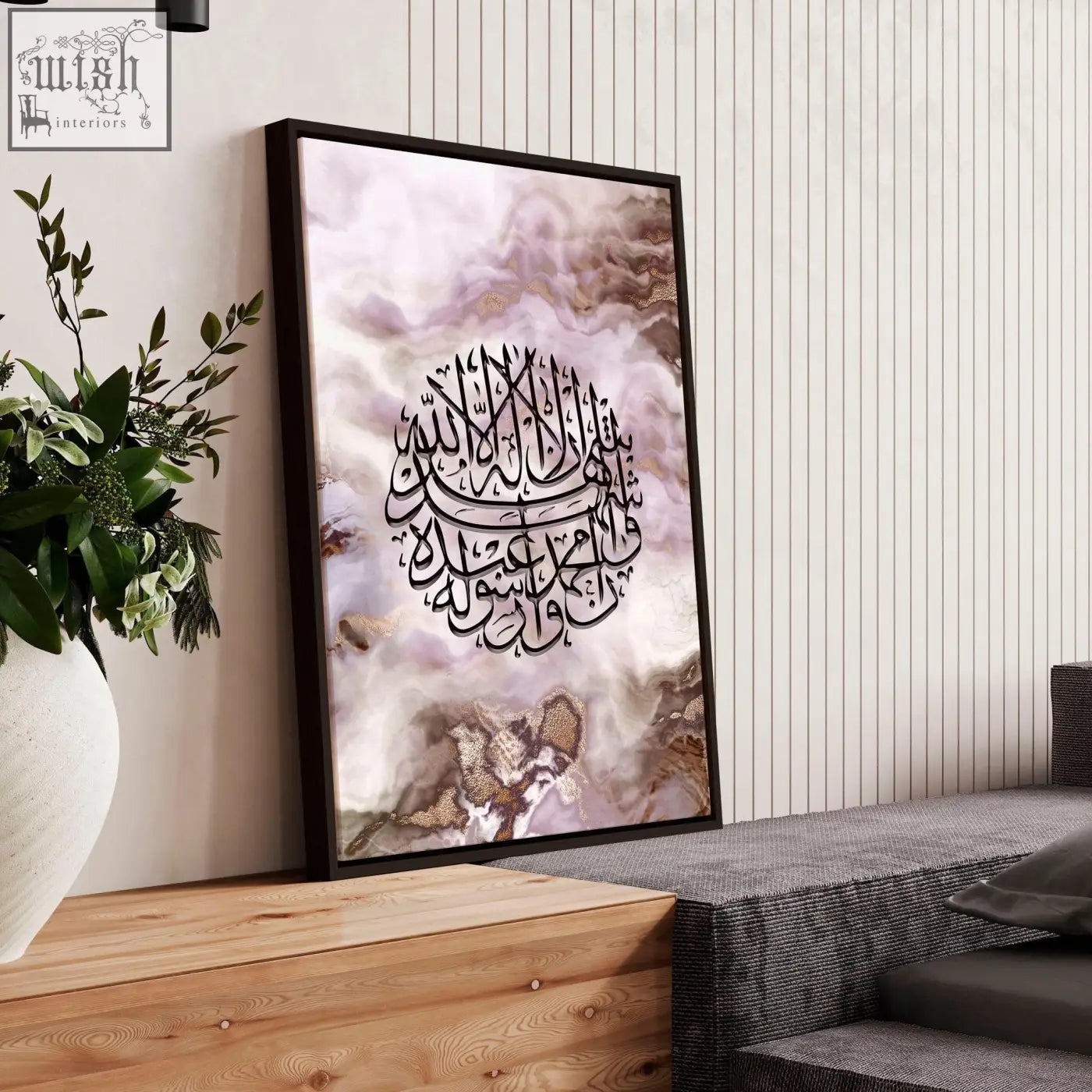 A framed islamic wall art with black calligraphy on a lavender and beige marble background in a dark frame
