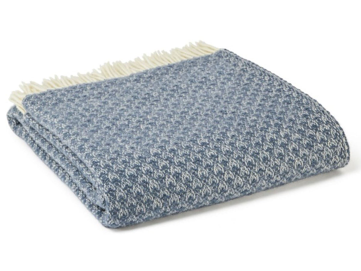 A folded gray and white textured wool throw with cream fringe from isobel crescent blue slate drapers collection