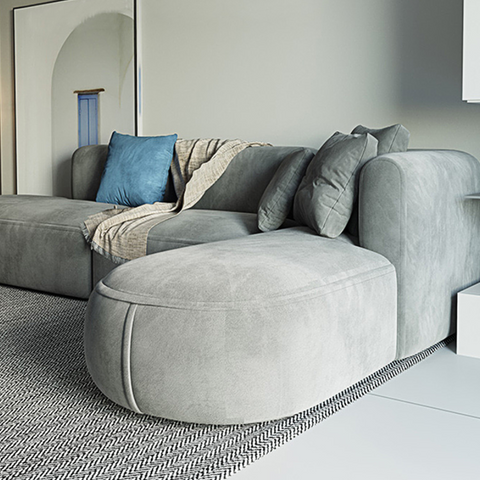 Modern gray suede isolde three seater corner sofa with plush cushions and blue throw pillow in grey velvet