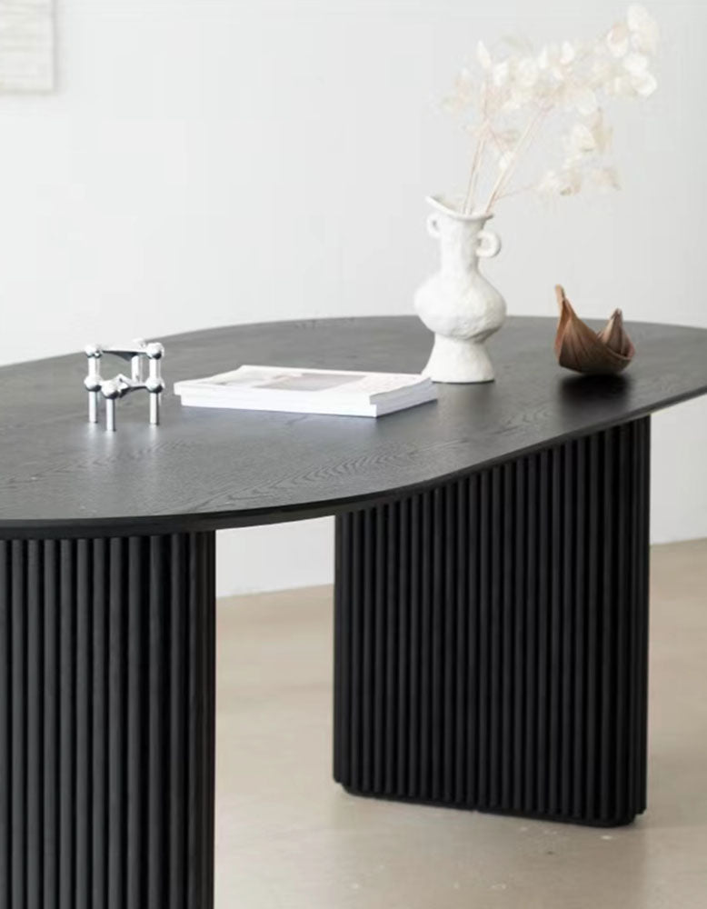 Black ivar oval dining table with solid wood vertical ribbed legs and a smooth matte finish oval dining table