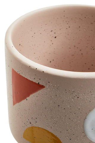 A jada small abstract ceramic planter with a speckled beige matte finish and coral mustard geometric shapes