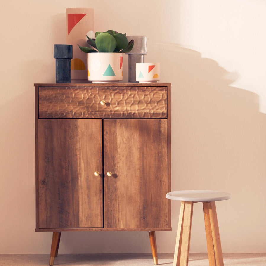 Warm-toned wooden cabinet with hammered metal drawer front and matching knobs for jada small abstract planter setup