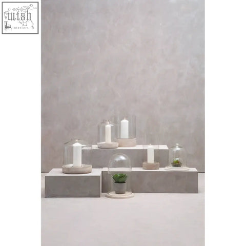 Jain large hurricane candle holder with glass dome and white candle on a circular concrete base large hurricane candle