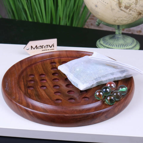 Rich brown wooden jajur wooden solitaire game board with smooth polished surface and evenly spaced holes