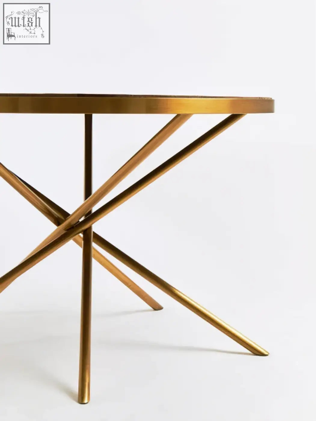 Gold-finished metal table with circular top and intersecting legs complementing jana round fir wood dining table design