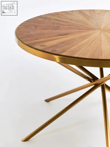 Golden metal dining table with a circular fir wood top featuring radial wood grain patterns jana round fir table