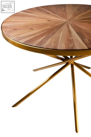 Golden metal table with a circular jana round fir wood dining table top showing radial wood grain patterns