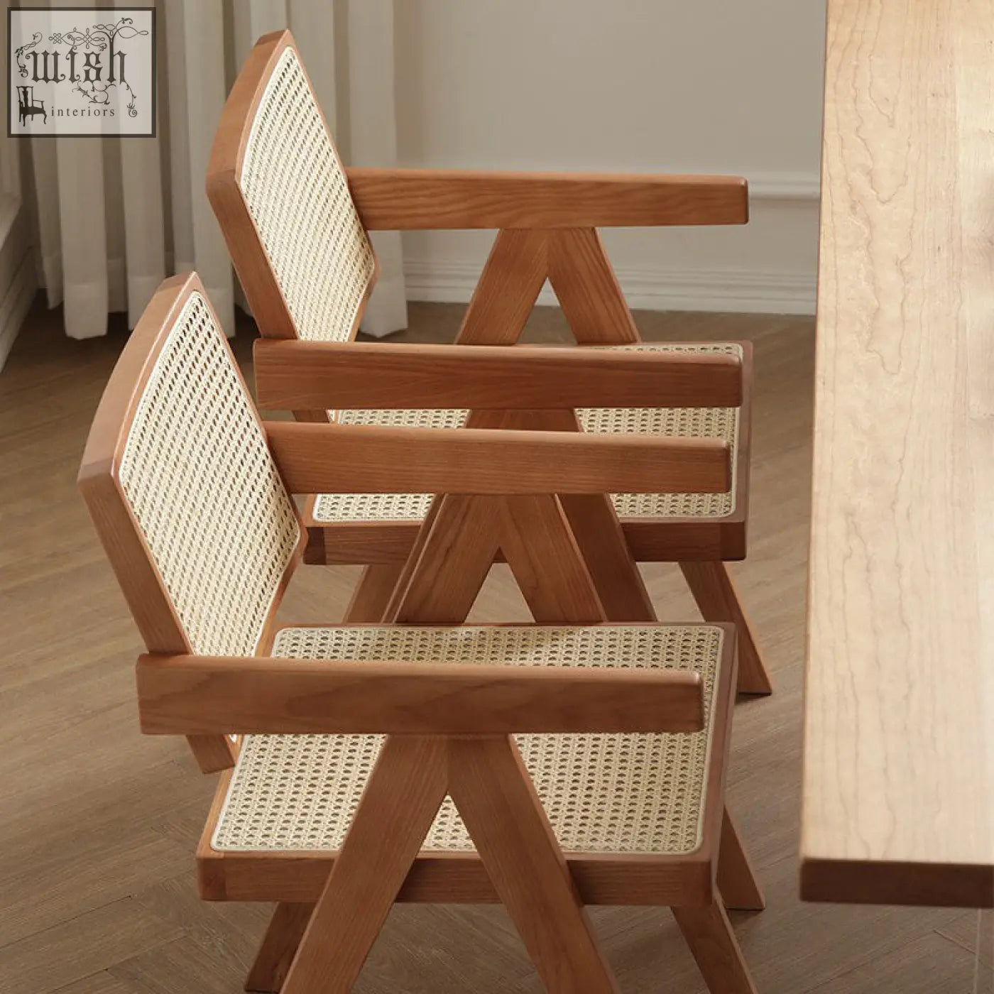 Two jane rattan dining chairs with light wood x-shaped legs and woven cane seats perfect for rattan dining rooms