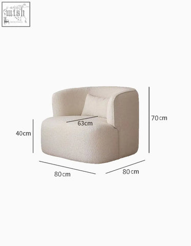 Cream-colored janet armchair with plush velvet boucle texture and rounded modern design with matching cushion