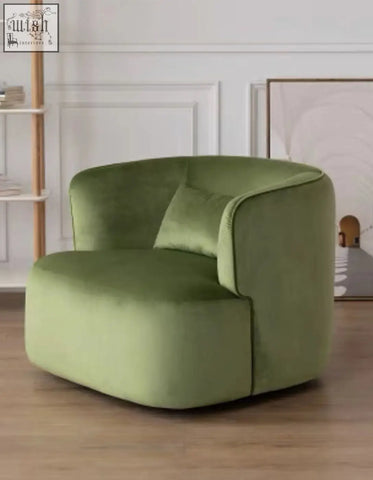 A plush green velvet armchair with a rounded modern design and matching cushion called janet armchair velvet boucle