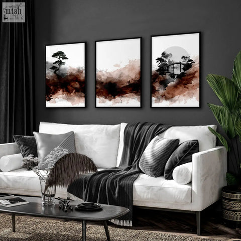 Three framed japandi ink wash wall art pieces in brown tones hang above a modern white living room sofa