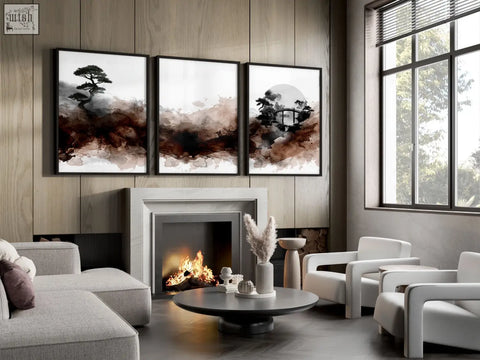 Three framed minimalist ink wash wall art in brown tones featuring pine trees hang above a living room fireplace