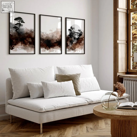 Three framed japandi ink wash wall art prints with black tree silhouettes and brown tones above a white living room sofa