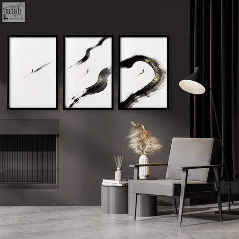 Three framed black and white japandi wall decor prints with bold brushstrokes and gold toned accents on a dark wall