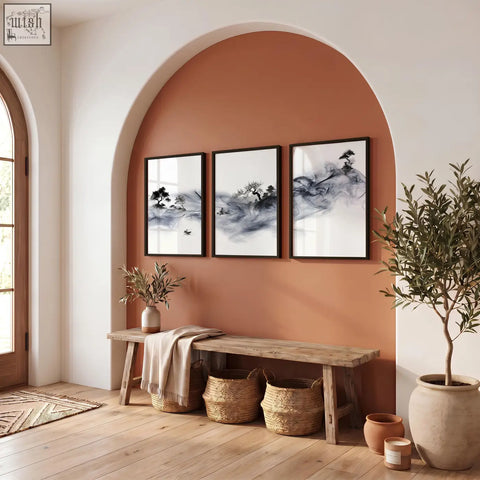 Three framed black and white ink wash landscape art prints with fisherman trees and pagoda hanging above a wooden bench