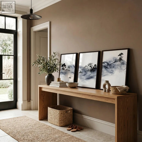 Three framed black and white ink wash landscape art prints featuring fisherman trees and pagoda on brown wall